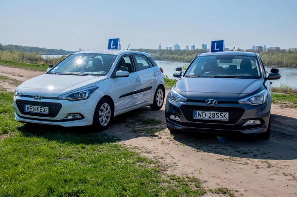 Samochody szkoły jazdy Auto-Stop na tle panoramy Warszawy